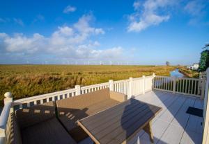 a bench on a balcony with a view of a field at MP261 Parkdean Camber Sands in Camber