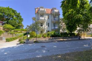 a white building on the side of a street at Ferienzimmer Küstensonne in Zinnowitz +4 photos