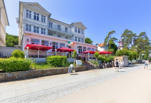 a row of buildings with red umbrellas on a street at Ferienzimmer Küstensonne in Zinnowitz