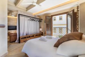 une chambre avec un grand lit blanc et une fenêtre dans l'établissement BHost - Puro Tarifa, à Tarifa