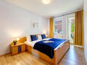 une chambre avec un lit avec des draps bleus et une fenêtre dans l'établissement Ostseepark Waterfront Karavelle Wohnung 3.5, à Bansin 16 autres photos