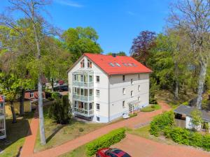 une vue aérienne sur une maison blanche avec un toit rouge dans l'établissement Ostseepark Waterfront Karavelle Wohnung 3.5, à Bansin