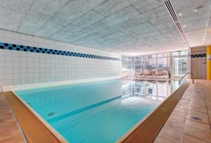 une grande piscine avec des carreaux bleus sur le mur dans l'établissement Ostseepark Waterfront Karavelle Wohnung 3.5, à Bansin