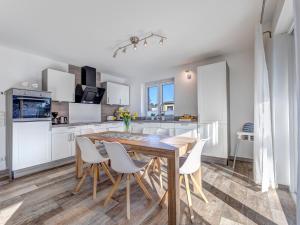 a kitchen and dining room with a wooden table and chairs at Villa Maarten mit Sauna in Zempin