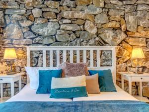 a bed in a room with a stone wall at Villa Maarten mit Sauna in Zempin