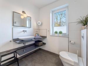 a white bathroom with a sink and a toilet at Villa Maarten mit Sauna in Zempin +24 photos