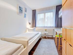 a hotel room with two beds and a desk at Villa Madeleine KU 08 in Bansin