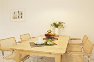 a wooden table with chairs and a bowl of fruit on it at Residenz Waldhaus_05 in Zempin