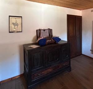 an old wooden cabinet with a suitcase on top of it at B&B Gennarcu in Ussàssai