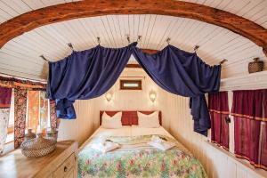 a bedroom with a bed in a room with blue curtains at Kleiner Wagen - Stubbenfelde in Stubbenfelde