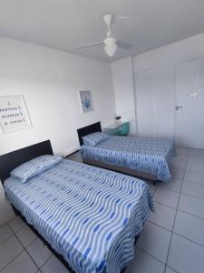 two beds sitting next to each other in a room at Apto 2 quartos em frente à praça nova do Imbui Excelente localização in Salvador