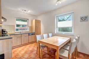 a kitchen with a wooden table and chairs at Ferienhaus "Krabbe" in Ostseebad Karlshagen