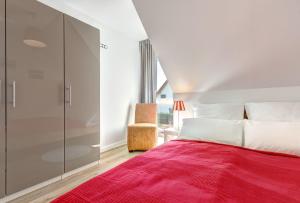 Un dormitorio con una cama roja y una silla. en Haus Wellenreiter, en Bansin