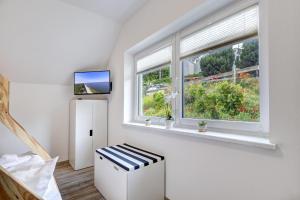 a room with a window and a stool and a television at Haus Strandkörv mit Fass-Sauna in Loddin