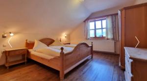a bedroom with a wooden bed and a window at Ferienhaus Türlinger in Schorndorf