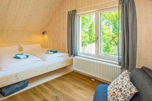 StubbenfeldeにあるSeehaus Söt Mine mit Saunaのベッドと窓のある小さな寝室