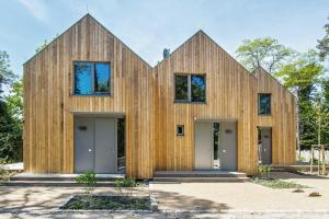 a house clad in wood with two towers at Seehaus Lütt Marten in Stubbenfelde