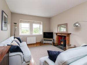 ein Wohnzimmer mit zwei Sofas und einem Kamin in der Unterkunft Camisky Steading in Fort William
