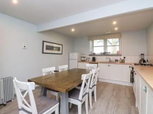 eine Küche mit einem Holztisch und weißen Schränken in der Unterkunft Camisky Steading in Fort William