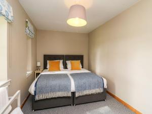 ein Schlafzimmer mit einem großen Bett mit orangefarbenen Kissen in der Unterkunft Camisky Steading in Fort William