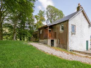 ein altes Steinhaus mit Balkon an der Seite in der Unterkunft Camisky Steading in Fort William