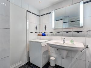 Villa Strandperle Wohnung 28/29 Bansin في بانسين: حمام أبيض مع حوض ومرآة