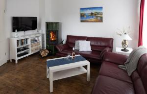 un salon avec un canapé et une télévision dans l'établissement Meerferienhaus - Haus Schlehenweg, à Zinnowitz