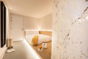a bedroom with a white bed and a wall at Zedwell Underground Hotel Tottenham Court Rd in London