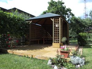 a wooden gazebo with a wooden deck in a yard at VIIVE KONI Home Accommodation in Tartu