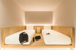 a small room with two beds and a backpack at Zedwell Underground Hotel Tottenham Court Rd in London