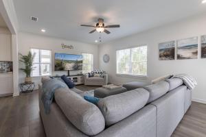 a living room with a large couch and a ceiling fan at Bay Breeze Retreat in Orange Beach
