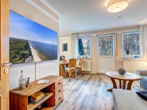 a living room with a table and a large window at Haus Sonnenschein FeWo Seepferdchen in Trassenheide