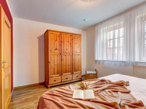 a bedroom with a bed and a wooden cabinet at Haus Sonnenschein FeWo Seepferdchen in Trassenheide