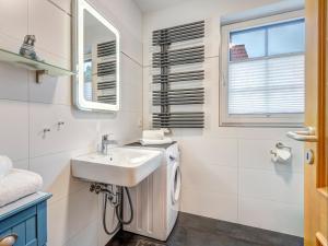 a bathroom with a sink and a washing machine at Haus Sonnenschein FeWo Seepferdchen in Trassenheide +7 photos