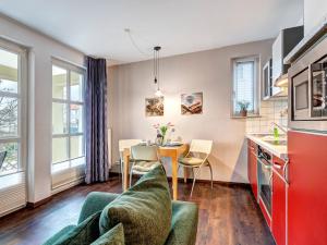 eine Küche und ein Wohnzimmer mit einer Couch und einem Tisch in der Unterkunft Villa Margot - FeWo 02 in Bansin