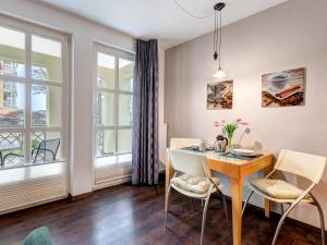 ein Esszimmer mit Tisch und Stühlen und Fenstern in der Unterkunft Villa Margot - FeWo 02 in Bansin