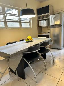 une cuisine avec une table avec des chaises et un réfrigérateur dans l'établissement Villa Ruth, a casa que voce vai amar, à Torres