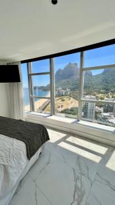 a bedroom with a large window with a view at Quarto no Hotel Nacional Rio de Janeiro in Rio de Janeiro