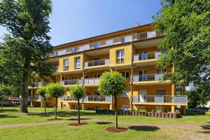 Un edificio de apartamentos con árboles en frente. en Ferienwohnung Seestraße, en Zempin