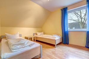 two beds in a room with a window at Ferienhaus "Seestern" in Karlshagen