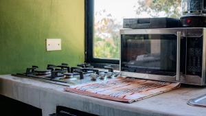 a microwave oven sitting on top of a stove at Charming Tiny House with Small Pool & Fire Pit in Lagartero