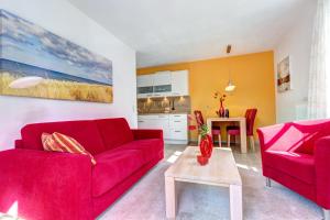 a living room with two red couches and a table at Residenz am Balmer See - BS 45 mit Wellnessbereich in Balm