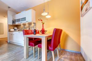 a dining room with a table and red chairs at Residenz am Balmer See - BS 45 mit Wellnessbereich in Balm +16 photos