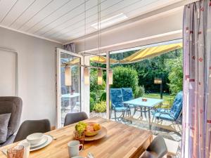 Un comedor con una mesa y un gran ventanal. en Bungalow Jonas, en Trassenheide 5 fotos más