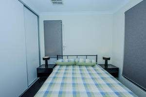 a bedroom with a bed with a checkered blanket at Spectacular 3 Bedroom, 2 Bathroom Home. in West Swan
