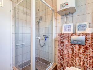 y baño con ducha y azulejos rojos. en Bungalow Jonas, en Trassenheide
