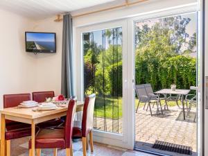 comedor con puerta corredera de cristal que conduce a un patio en Bungalow Konrad, en Trassenheide
