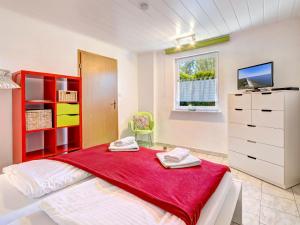 Un dormitorio con una cama con una manta roja. en Bungalow Konrad, en Trassenheide