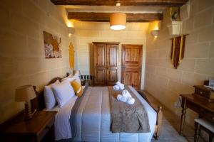 a bedroom with a bed with towels on it at Il figolla farmhouse in Xagħra