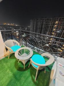 a balcony with three chairs and a table on top at 1001 new hazratganj in Nilmatha +6 photos